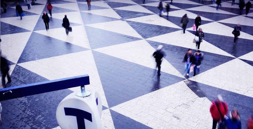 people walking over a black and white geometric floor