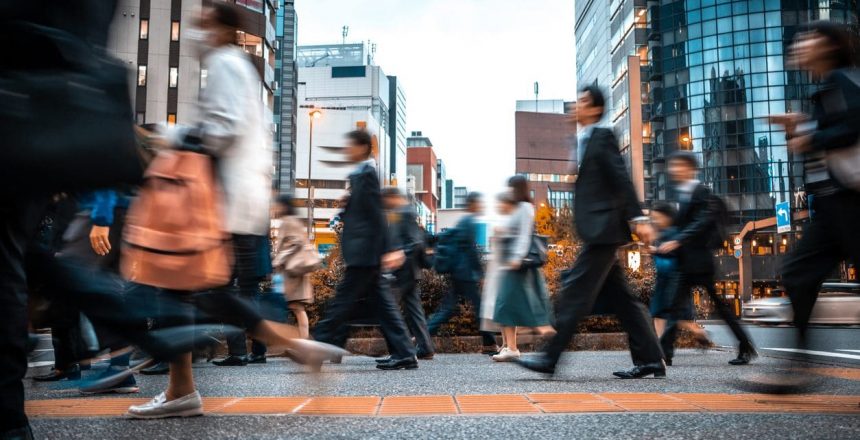 Crowd of business people on their way from work. They are unrecognisable. Long exposure shot.